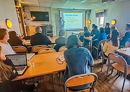 Students and lecturer in a small lecture room.