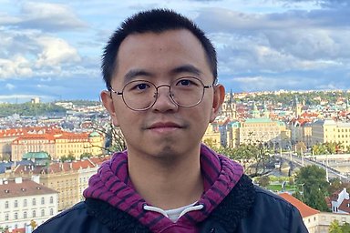 Weiwen Lai on a sunny summer day standing on a hill with Stockholm in the background.