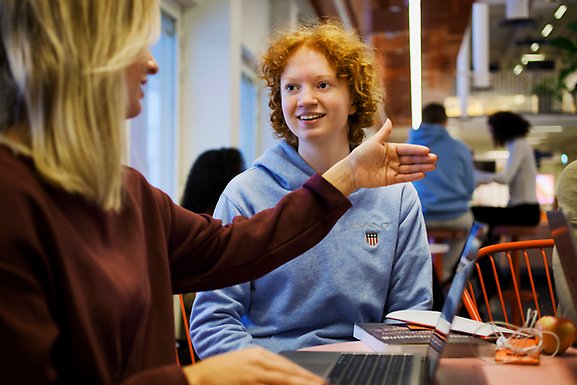 A womnan explaning something to a student.