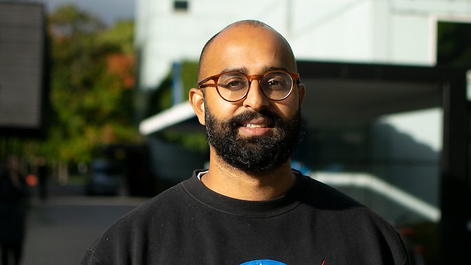 Porträttfoto på Siddartha Aradhya med campusbyggnader i bakgrunden.