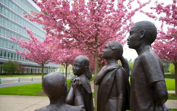 Staty i gjuten brons och sten som föreställer fyra personer, där en är en flicka som vaccineras