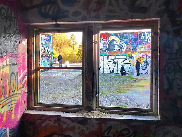 Öppet fönster, utanför syns väggar med graffitimålningar.