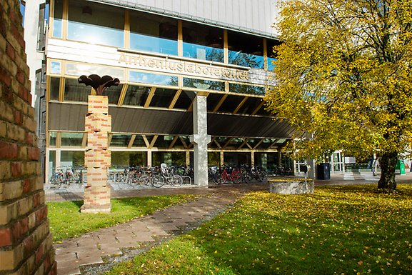 Utanför huvudingång till byggnaden Arrheniuslaboratoriet. Till höger ett träd samt löv på marken.