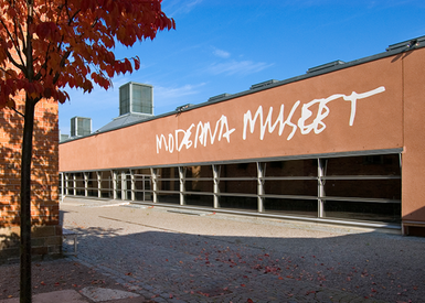 Utsidan av Moderna museet, en låg byggnad i brun puts.