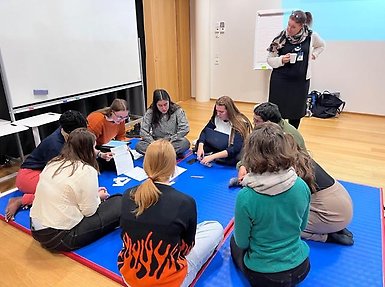 Students sitting on the floor in a circle