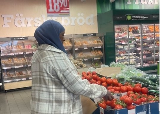 Kvinna köper tomater i en butik