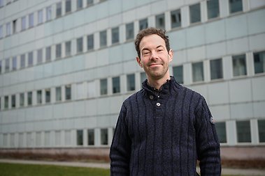 Kieron Barclay standing outside, campus building in the background.