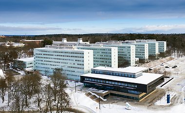 Drönarbild över Stockholms universitet i vinterskrud.