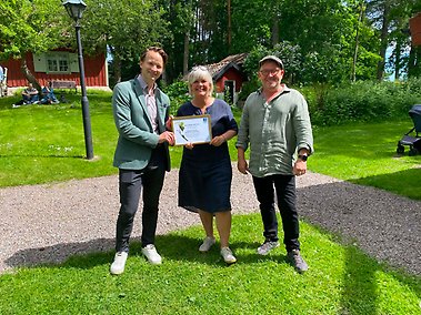 Pristagare Eva Lindell och Mattias Murphy (till höger) får utmärkelse av Trosa kommuns Rasmus Deltéus (till vänster). Foto: Trostorp