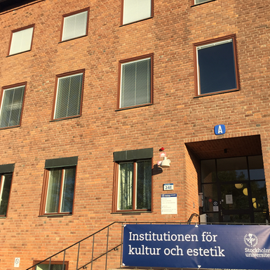 Ingången till Institutionen för kultur och estetik, brun tegelbyggnad med en trappa upp till dörren.