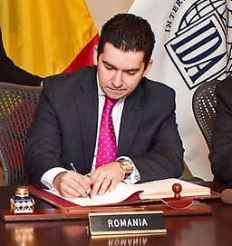 Man sitting at a desk signing an agreement.