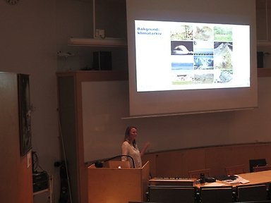 Jenny Sjöström framför filmduken och föreläser, nordenskiöldsalen, stockholm universitet