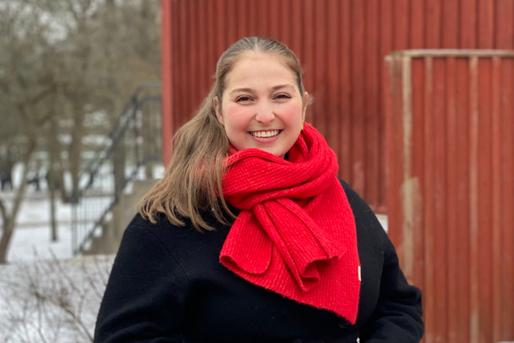 Flore Debruyne står utomhus med snö och ett trähus i bakgrunden.