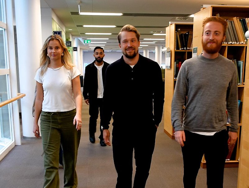 Researcher with students in the library.