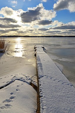 Brygga i vinterlandskap.