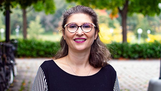 Eleonora Mussino står utomhus på campus, cyklar och grönska i bakgrunden.