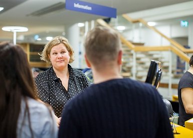 Studenter pratar med bibliotekspersonal.