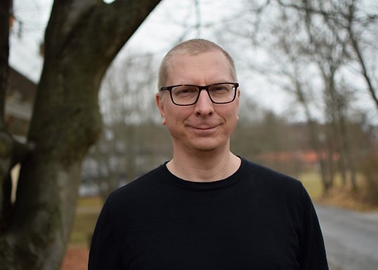 Martin Hällsten står i en park, en höstdag.