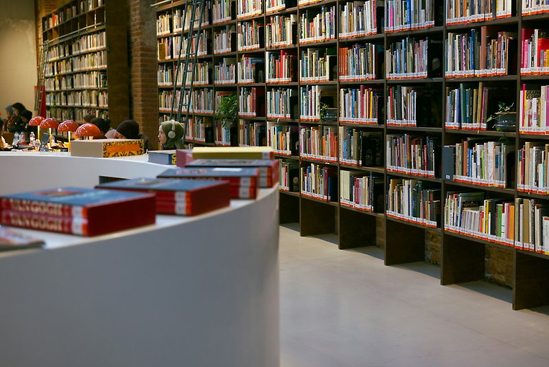 White desk at a library with people reading in the background