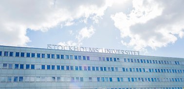 Bild på en av de ljusblåa byggnaderna vid Stockholms universitet.