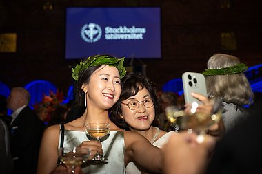 Woman with laurel wreath taking a selfie of herself and a friend