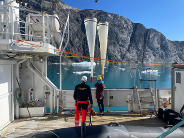 Scientists deploying a Bongo net from a research vessel outside the fjords of southeast Greenland.