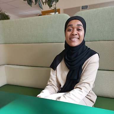 Studentambassadör Sophea sitter i en av sofforna i studentkorridoren på BUV.