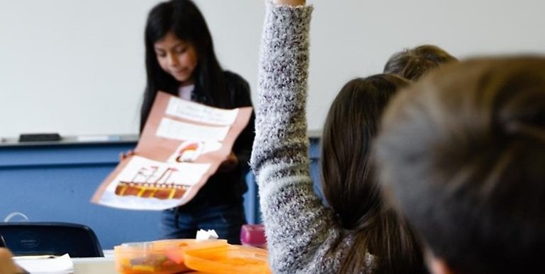 Skolflicka presenterar sitt arbete inför klassen.