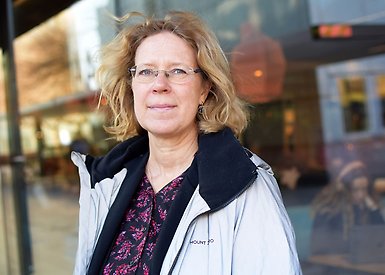 Ann-Zofie Duvander står utomhus framför en glasfasad.