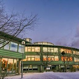 Green buildings with the sunset reflecting in the windows, winter dusk.
