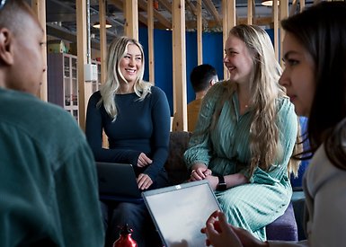 Studenter i samtal sittandes i korridor.