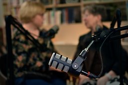 Mikrofon med två personer i bakgrunden.