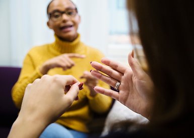 Två studenter sitter och tecknar, den ena personens händer syns litegrand snett bakifråm.