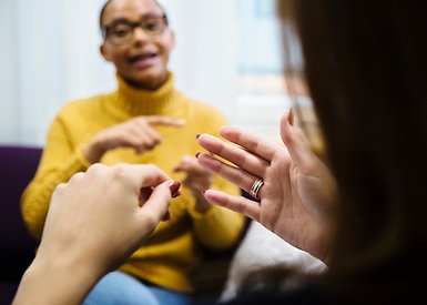 Två studenter tecknar med varandra.